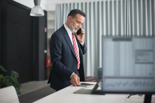 Professional man in a business suit on a phone call in a modern office setting.